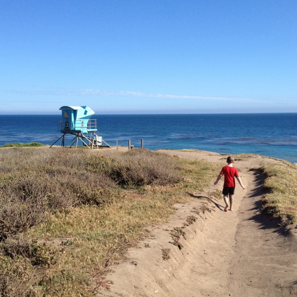 boy walks on ocean cliff