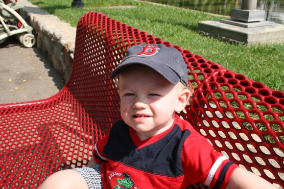 toddler on red bench baseball hat