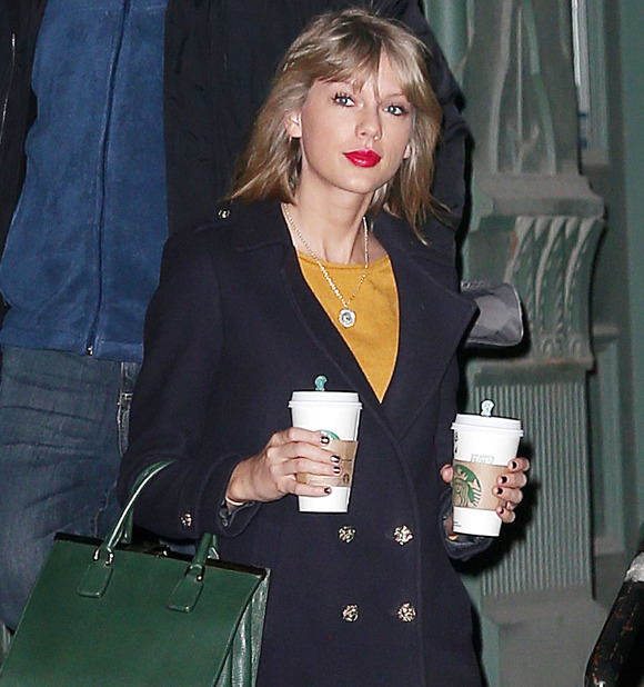 Taylor Swift walks out of her apartment double-fisting two grande Starbucks coffees, wearing red pants and carrying a green purse on New Year's Day in NYC