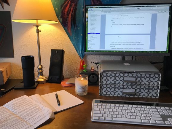 desk with computer and lit candle