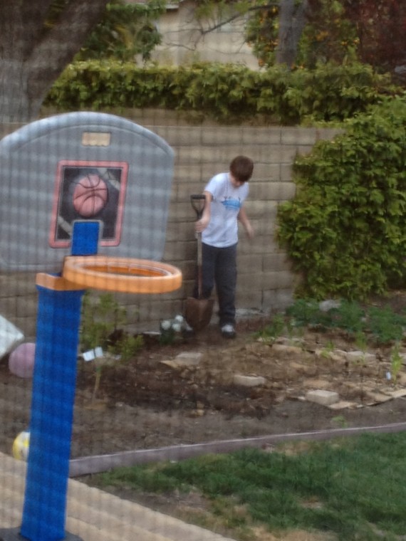 kid digging hole in garden