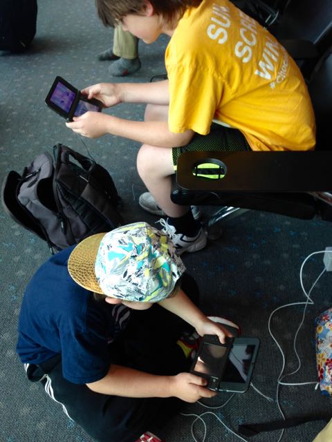 boys playing Nintendo 3DS at airport